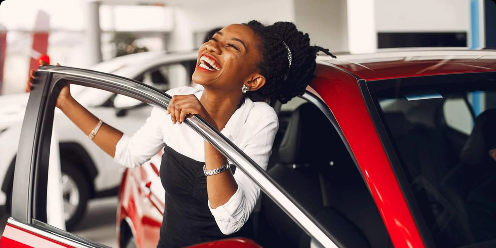 Happy woman celebrating beside a red car