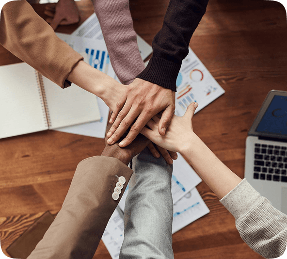 Whipcare team stacking hands over a desk